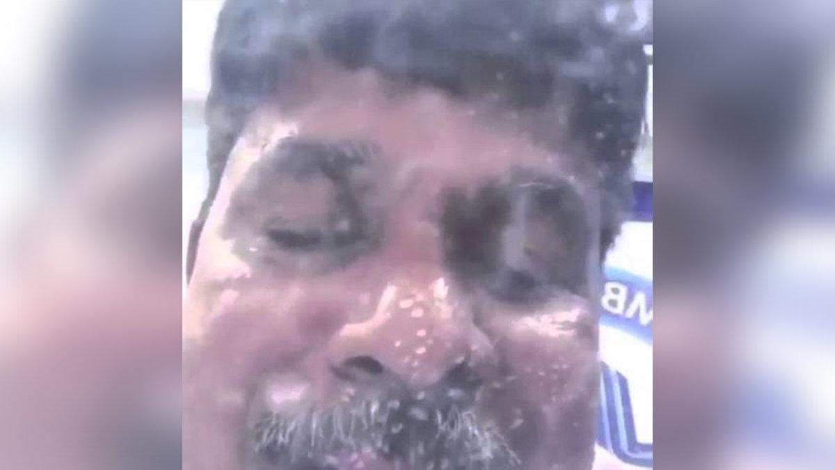 Close-up of a man's face with wet skin and droplets of water, possibly of South Asian descent
